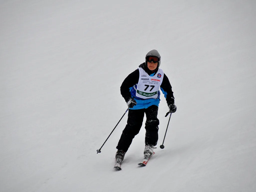 Skifahrer mit Startnummer 77 auf der Rennstrecke.